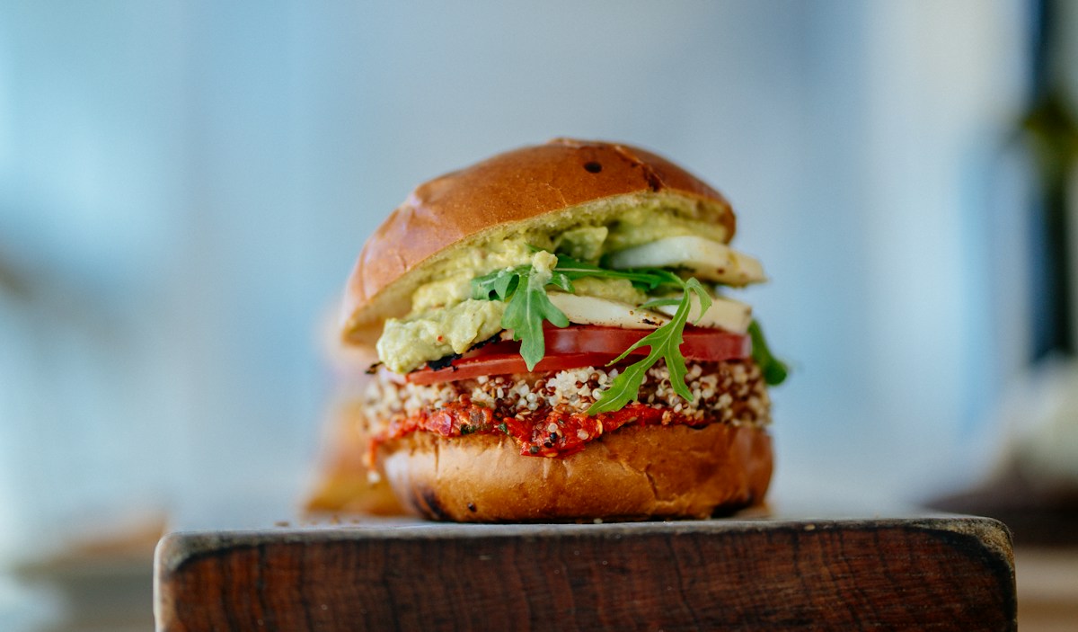 A burger with fresh vegetable toppings